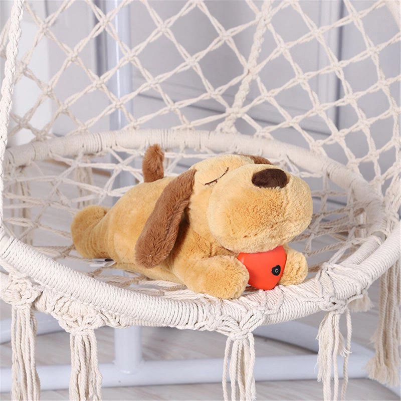 Calming Frenchie Heartbeat Toy plush lying on a hanging macrame chair
