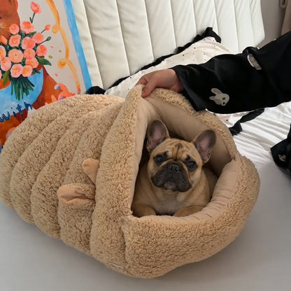 Beige Lamb Frenchie Cave Bed with the front flap lifted and a fawn French bulldog resting inside